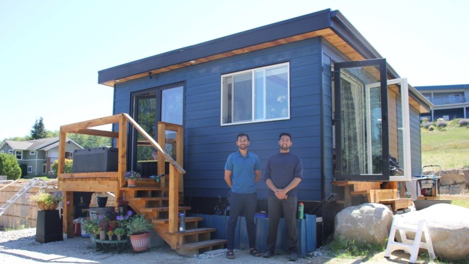 Rohan and Salik standing in front of single story Lotus Mini Prefabricated home