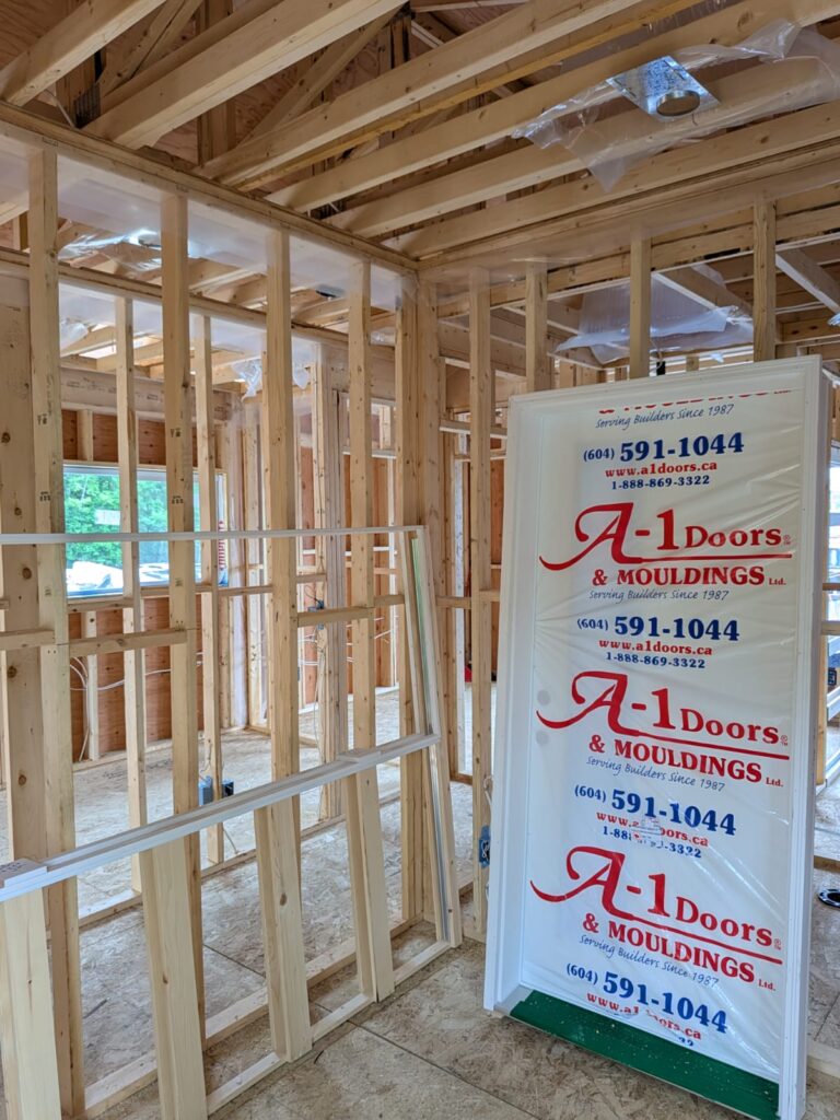 Wrapped up doors ready for installing in framing of Surrey intergenerational home project.